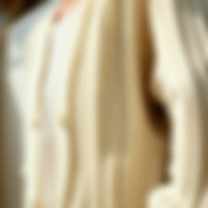 Close-up of soft, textured fabric of a white knit cardigan.